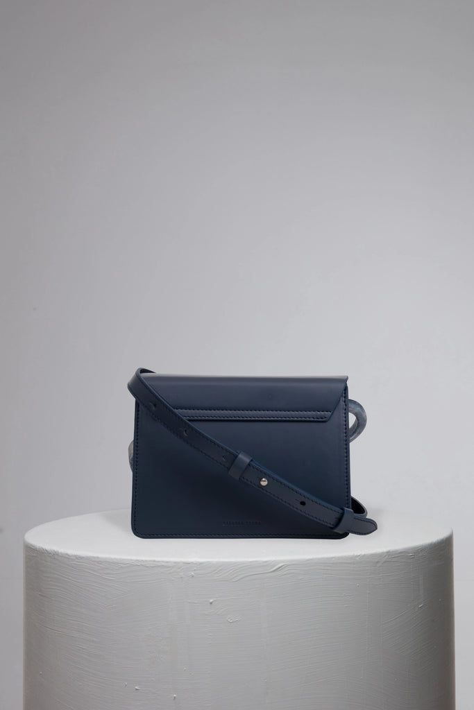 Navy geunine leather handbag on grey stand