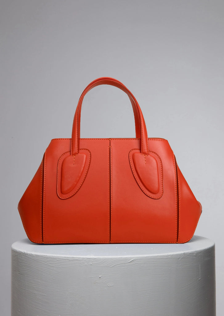 medium orange calf leather woman handbag on grey stand
