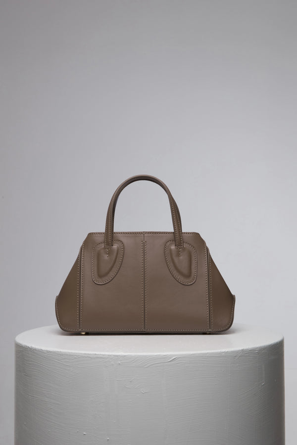brown leather handbag with two strap on white stant
