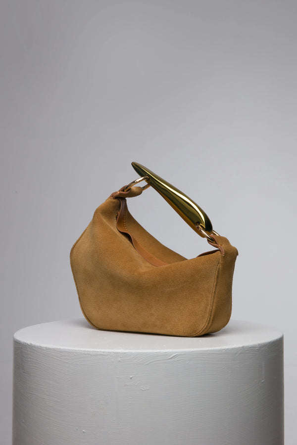 Brown suede leather soft handbag with metal handle on a white stand