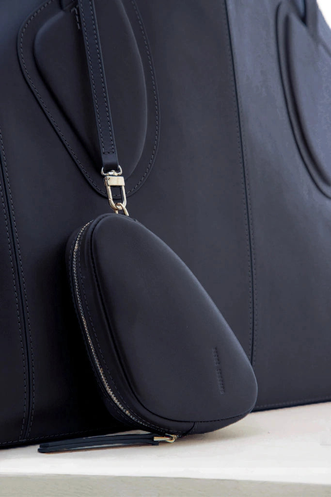 Calf leather maxi non-structured rectangle tote bag with non-removable two leather handle and two leather shoulder strap on a white stand