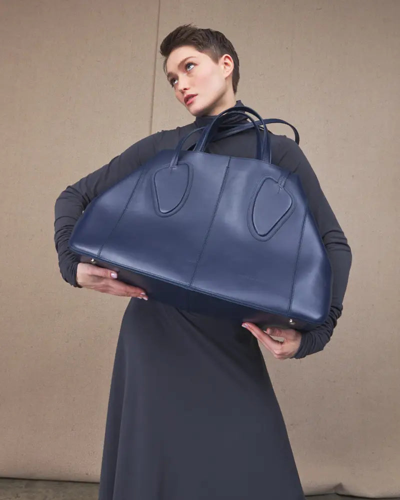 Blue calf leather maxi non-structured rectangle tote bag on a woman