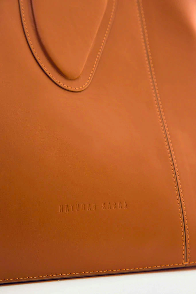 Calf leather maxi non-structured rectangle tote bag with non-removable two leather handle and two leather shoulder strap on a white stand