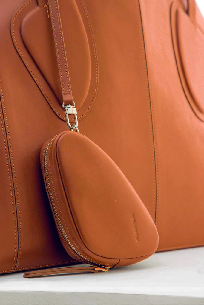 Calf leather maxi non-structured rectangle tote bag with non-removable two leather handle and two leather shoulder strap on a white stand