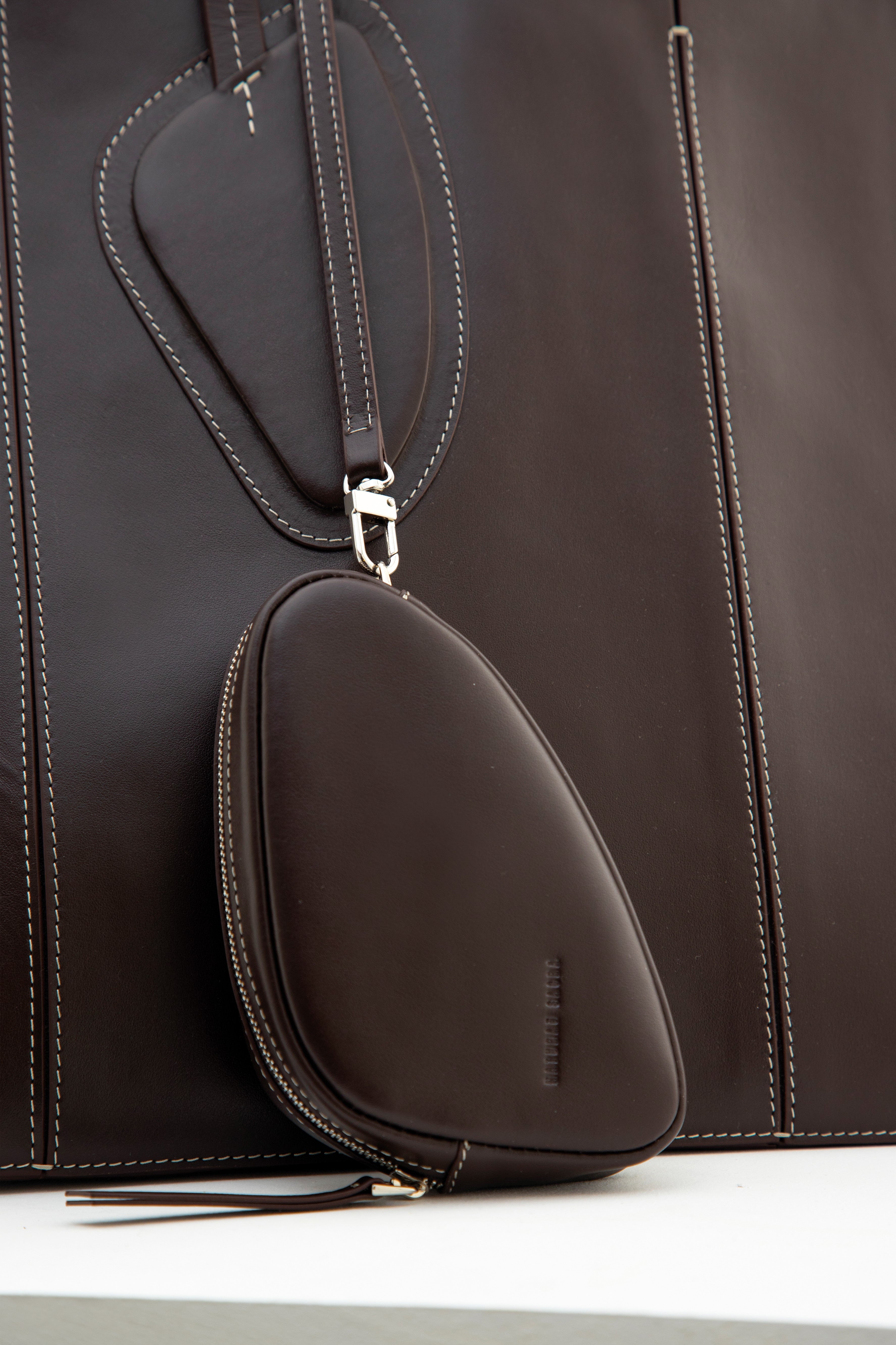 Calf leather maxi non-structured rectangle tote bag with non-removable two leather handle and two leather shoulder strap  on a white stand