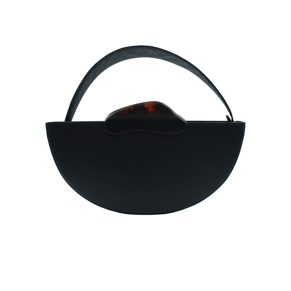 Flat topped oval structured black calf leather hand bag with two natural resin round handles and a removable calf leather strap on a white stand