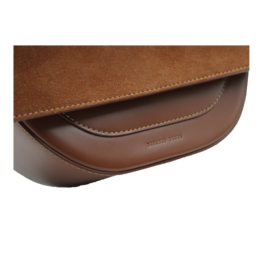 Rectangle shaped brown calf leather saddle bag with natural resin handle holder and remowable calf leather handle strap on a white stand