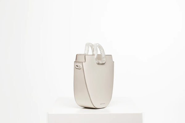 Midi flat topped oval structured off white calf leather tote bag with natural resin round handles and a removable adjustable calf leather strap
