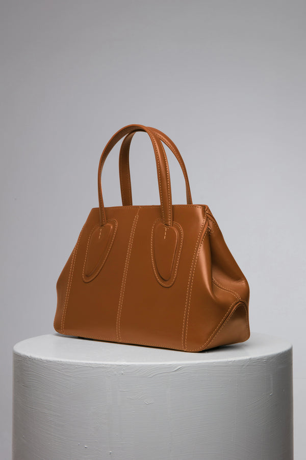 brown leather handbag on white stand