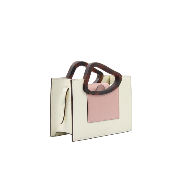 Rectangle shaped dusty rose calf leather saddle bag with natural resin handle holder and remowable calf leather handle strap on a white stand