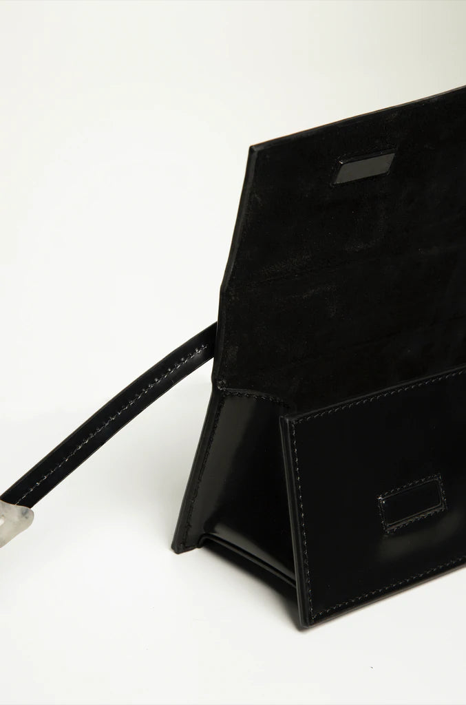 Rectangle shaped black calf leather clutch bag with natural resin filled in handles and removable calf leather handle strap on a white stand