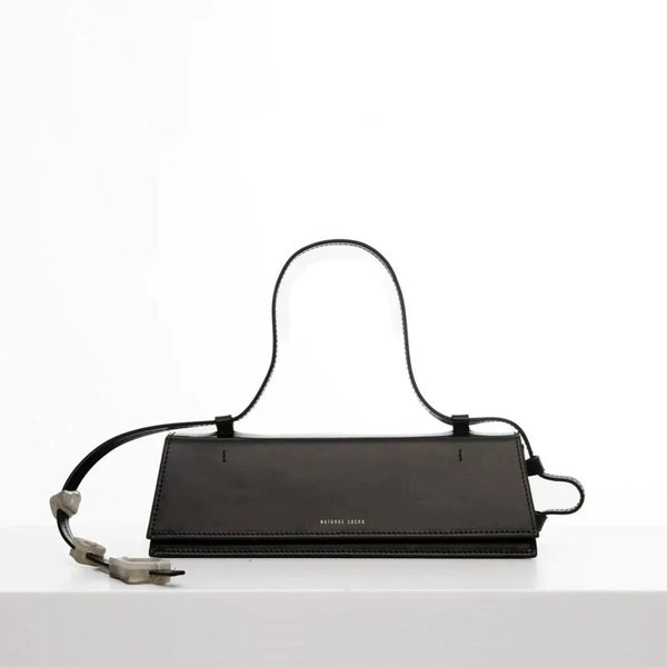 Rectangle shaped black calf leather clutch bag with natural resin filled in handles and removable calf leather handle strap on a white stand